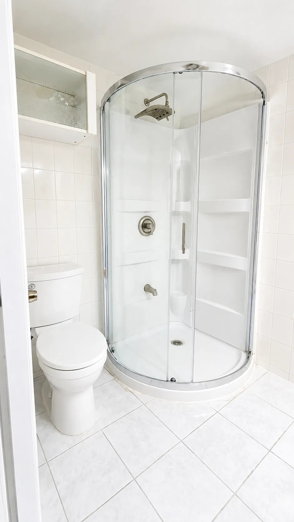Spotless white bathroom with a sparkling glass shower stall after a professional cleaning in Williston Park, New York
