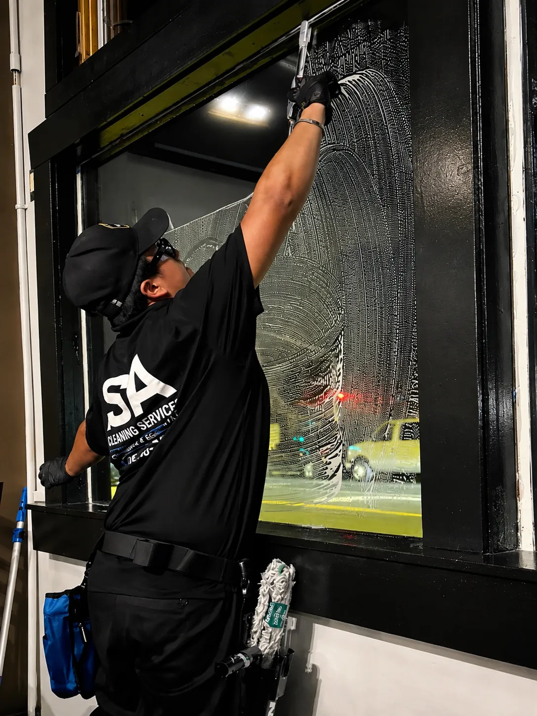 ISA Cleaning Services window cleaner using a squeegee on a large storefront window